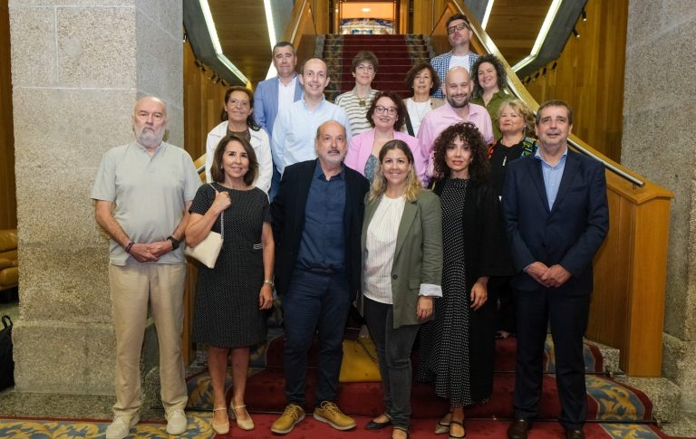 Grupo de personas posando en una escalera, sonriendo y vestidas de manera informal.